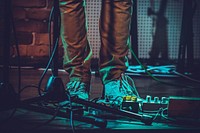 A close-up shot of a musician's shoes and music equipment. Original public domain image from Wikimedia Commons