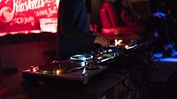 A DJ working their turntable at a club in Klaipėda. Original public domain image from <a href="https://commons.wikimedia.org/wiki/File:Spin_that_record_(Unsplash).jpg" target="_blank" rel="noopener noreferrer nofollow">Wikimedia Commons</a>