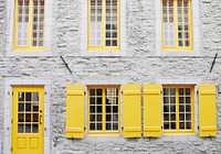 Yellow door and windows with yellow shutters in a white facade in Québec City. Original public domain image from Wikimedia Commons