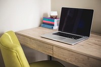 A MacBook next to a stack of books on a wooden desk. Original public domain image from <a href="https://commons.wikimedia.org/wiki/File:Laptop_and_books_(Unsplash).jpg" target="_blank" rel="noopener noreferrer nofollow">Wikimedia Commons</a>