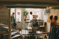 A busy living room with various trinkets and decorations and a window looking out on the street. Original public domain image from <a href="https://commons.wikimedia.org/wiki/File:Small_Amsterdam_storefront_(Unsplash).jpg" target="_blank" rel="noopener noreferrer nofollow">Wikimedia Commons</a>