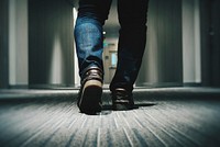 A low shot of a person in jeans walking through a hotel corridor. Original public domain image from <a href="https://commons.wikimedia.org/wiki/File:Feet_in_a_hotel_corridor_(Unsplash).jpg" target="_blank" rel="noopener noreferrer nofollow">Wikimedia Commons</a>