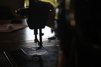 Macro of a sewing machine stitching in a dark room. Original public domain image from Wikimedia Commons