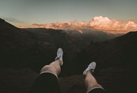 Legs outstretched into mountain, sunset background. Original public domain image from Wikimedia Commons