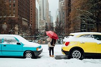 A person with an umbrella walking between two cars in New York. Original public domain image from <a href="https://commons.wikimedia.org/wiki/File:Colorful_Coincidence_(Unsplash).jpg" target="_blank" rel="noopener noreferrer nofollow">Wikimedia Commons</a>