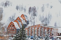 A tall snow covered mountain in the background of the Les 2 Alpes winter resort. Original public domain image from Wikimedia Commons