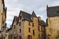 A landscape view of old buildings with windows and a tower in Sarlat P&eacute;rigord Foie Gras. Original public domain image from Wikimedia Commons