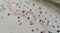 A drone shot of people vacationing on a beach with colorful umbrellas and towels. Original public domain image from <a href="https://commons.wikimedia.org/wiki/File:From_Above_(Unsplash).jpg" target="_blank" rel="noopener noreferrer nofollow">Wikimedia Commons</a>