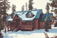 A snow covered log cabin in the forest surrounded by pine trees. Original public domain image from Wikimedia Commons