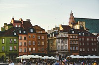Tourists strolling near quaint tenement houses in the Castle Square in Warsaw. Original public domain image from <a href="https://commons.wikimedia.org/wiki/File:Tourists_at_a_historic_square_(Unsplash).jpg" target="_blank" rel="noopener noreferrer nofollow">Wikimedia Commons</a>