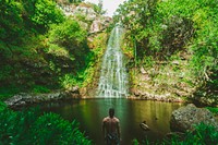 A bare-chested man standing near a small waterfall. Original public domain image from Wikimedia Commons