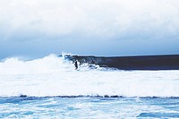 A distant surfer riding a rough ocean wave in West Java. Original public domain image from <a href="https://commons.wikimedia.org/wiki/File:Riding_the_rough_waves_(Unsplash).jpg" target="_blank" rel="noopener noreferrer nofollow">Wikimedia Commons</a>