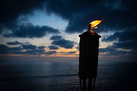 Torch burning after the sunset on the ocean shore at Carlsbad State Beach. Original public domain image from Wikimedia Commons