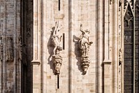 Religious stone church architecture and statue sculptures of human figures at Duomo di Milano. Original public domain image from Wikimedia Commons