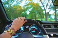 Shot of woman's hand with watch, bracelet and rings on steering wheel driving through Medford. Original public domain image from <a href="https://commons.wikimedia.org/wiki/File:Woman_hand_steering_wheel_(Unsplash).jpg" target="_blank" rel="noopener noreferrer nofollow">Wikimedia Commons</a>