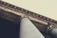A shot looking up at a pillar with greek architectural features. Original public domain image from <a href="https://commons.wikimedia.org/wiki/File:Greek_architecture_pillar_(Unsplash).jpg" target="_blank" rel="noopener noreferrer nofollow">Wikimedia Commons</a>