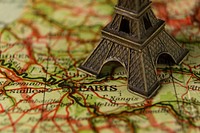 Eiffel tower miniature on a world map. Original public domain image from Wikimedia Commons
