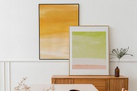 Picture frames with abstract wall art hanging and leaning on the living room wall