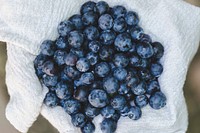 A bunch of blueberries on white textile. Original public domain image from Wikimedia Commons