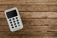 Eftpos machine on a wooden table with design space aerial view