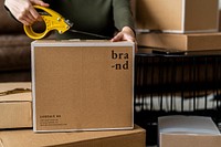 Small business owner packing product parcel boxes for delivery