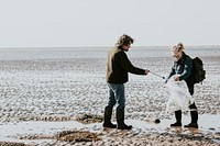 Beach cleanup volunteers picking up trash for environment campaign