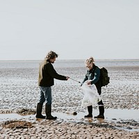 Beach cleanup volunteers picking up trash for environment campaign