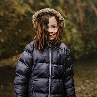 Little girl smiling in the forest on a family trip portrait