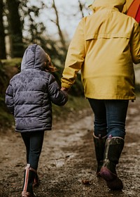 Mother walking with her daughters in the forest rear view