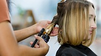 Woman getting her hair curled at a beauty salon 