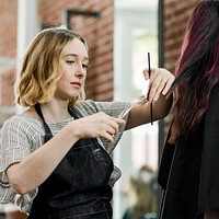 Hairdresser trimming the hair for the customer in a beauty salon