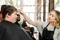 Hairstylist trimming hair of the customer in a beauty salon 
