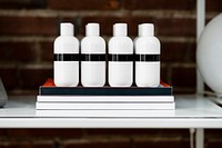 Four beauty product bottles on a shelf 