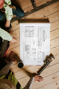 Contractors reading floor plan at a construction site