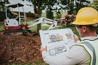 Contractor holding a floor plan at a construction site