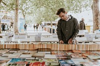 Man browsing secondhand books at street side used bookshop 