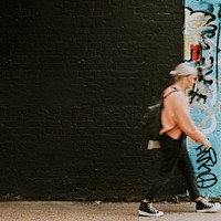 Woman walking past street art mural 