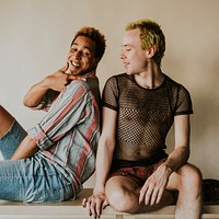 Playful gay couple sitting next to each other, LGBTQ