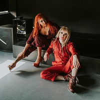 Drag show artists sitting by a stage