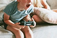 Young boy playing video game in living room