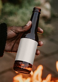 Man carrying a party cup by a fireside