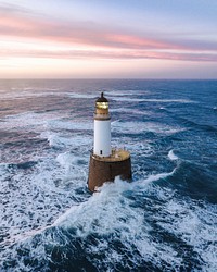 Waves hitting a lighthouse in Scotland