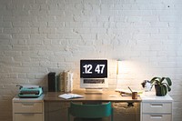 Free trendy, organized office desk with books, MacBook and a vintage typewriter, set against a painted brick wall image, public domain CC0 photo.