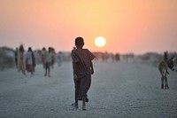 A Somali girl walks down a road at sunset in an IDP camp near the town of Jowhar. Original public domain image from <a href="https://www.flickr.com/photos/au_unistphotostream/11401553614/" target="_blank">Flickr</a>