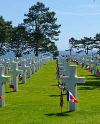 Normandy American Cemetery D-Day 70th. Gravemarkers rest near the sea during a ceremony honoring the fallen and living veterans of the D-Day landings at a ceremony. Original public domain image from Flickr