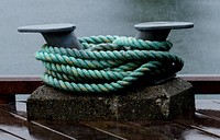A mooring refers to any permanent structure to which a vessel may be secured. Examples include quays, wharfs, jetties, piers, anchor buoys, and mooring buoys. A ship is secured to a mooring to forestall free movement of the ship on the water. An anchor mooring fixes a vessel's position relative to a point on the bottom of a waterway without connecting the vessel to shore. As a verb, mooring refers to the act of attaching a vessel to a mooring. Original public domain image from Flickr
