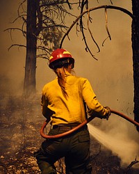 Woman outside of Redmond, OR uses a firehouse only for extreme precision to be part of the overall plan of a controlled burn. Original public domain image from Flickr