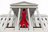 Red ribbon hangs from the North Portico of the White House for World AIDS Day. Original public domain image from Flickr