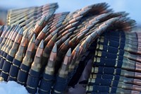 Linked belts of 7.62mm ammunition lays coiled on the ground as paratroopers assigned to the 2nd Battalion, 377th Parachute Field Artillery Regiment, 4th Infantry Brigade Combat Team (Airborne), 25th Infantry Division, U.S. Army Alaska, use M240B, and M2 machine guns while conducting live-fire qualification at Grezelka range, on Joint Base Elmendorf-Richardson, Alaska, Dec. 5, 2019. The Soldiers practiced identifying, and engaging targets at varying distances to solidify their proficiency with the weapons in sub-arctic conditions. (U.S. Air Force photo/Justin Connaher). Original public domain image from Flickr