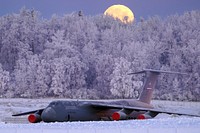 The waning gibbous moon is seen above a U.S. Air Force C-5 Galaxy transport aircraft on the flight line at Joint Base Elmendorf-Richardson, Alaska, Jan 10, 2020, as hoarfrost engulfs nearby trees in -16F weather while Airmen work around the plane. The C-5 enables the U.S. Air Force to provide heavy intercontinental-range strategic airlift capabilities, and is one of the largest aircraft in the world. (U.S. Air Force photo/Justin Connaher). Original public domain image from Flickr